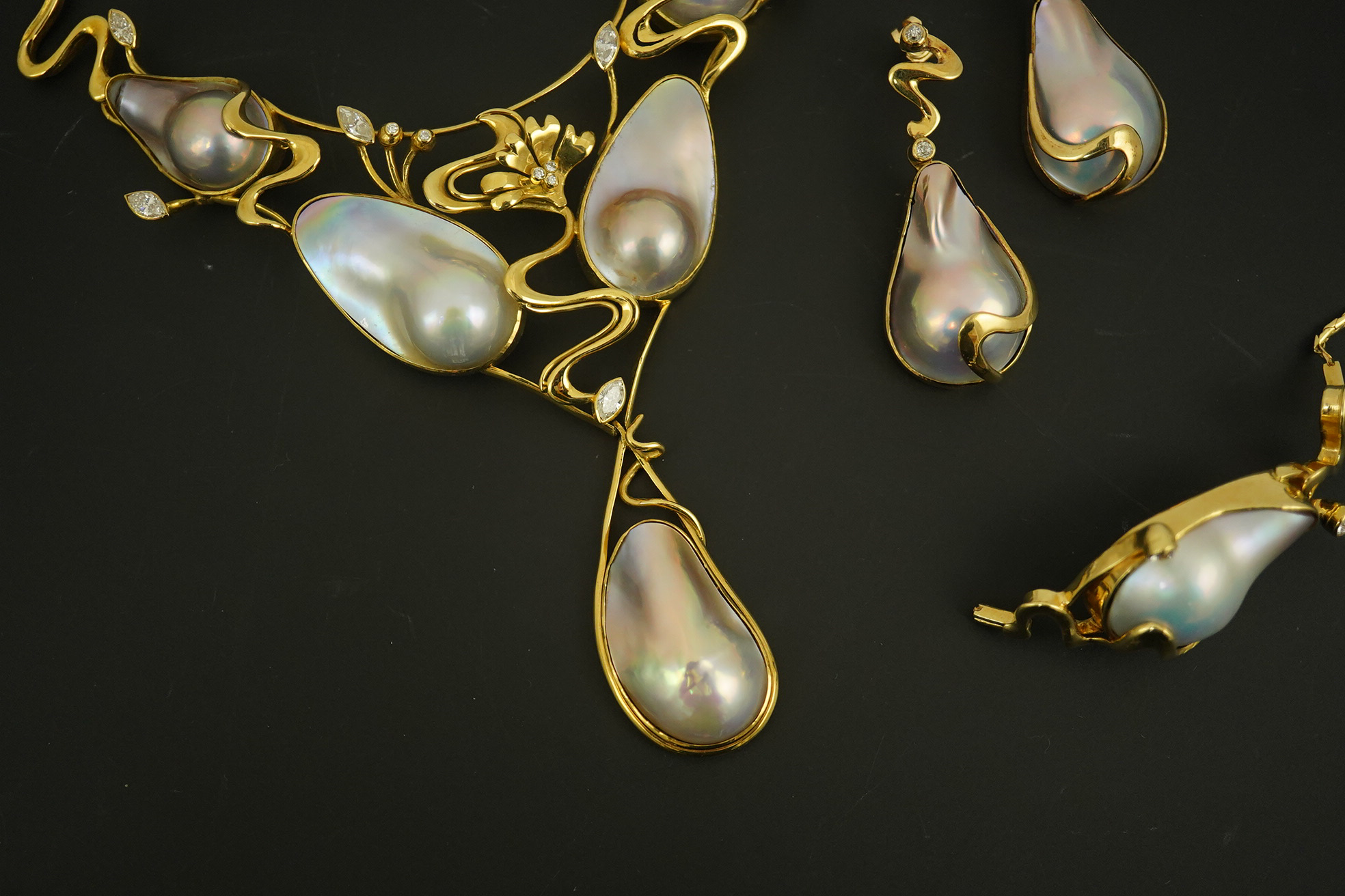 A modern suite of 18k gold, baroque pear, round and marquise diamond set jewellery